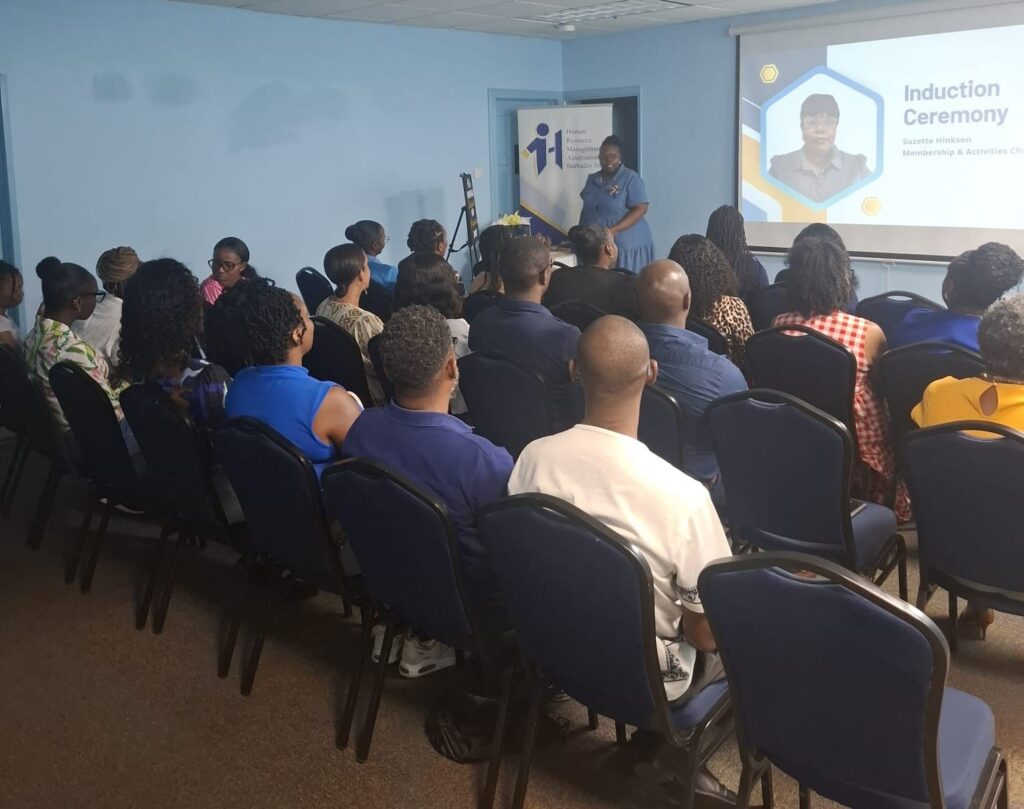 Members seated for the HRMAB new member induction ceremony, with the presentation on screen